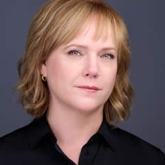 Headshot of criminal defense attorney in black shirt with red hair.