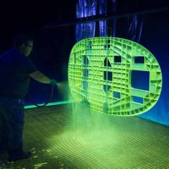 Painter Spraying Airplane Part Under Black Light Shows Step In A Manufacturing Process